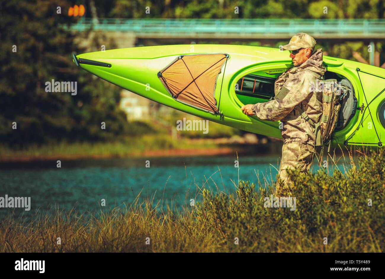 Uomini caucasici preparando per una gita in kayak o n e la Scenic River. Estate Tema di ricreazione. Foto Stock