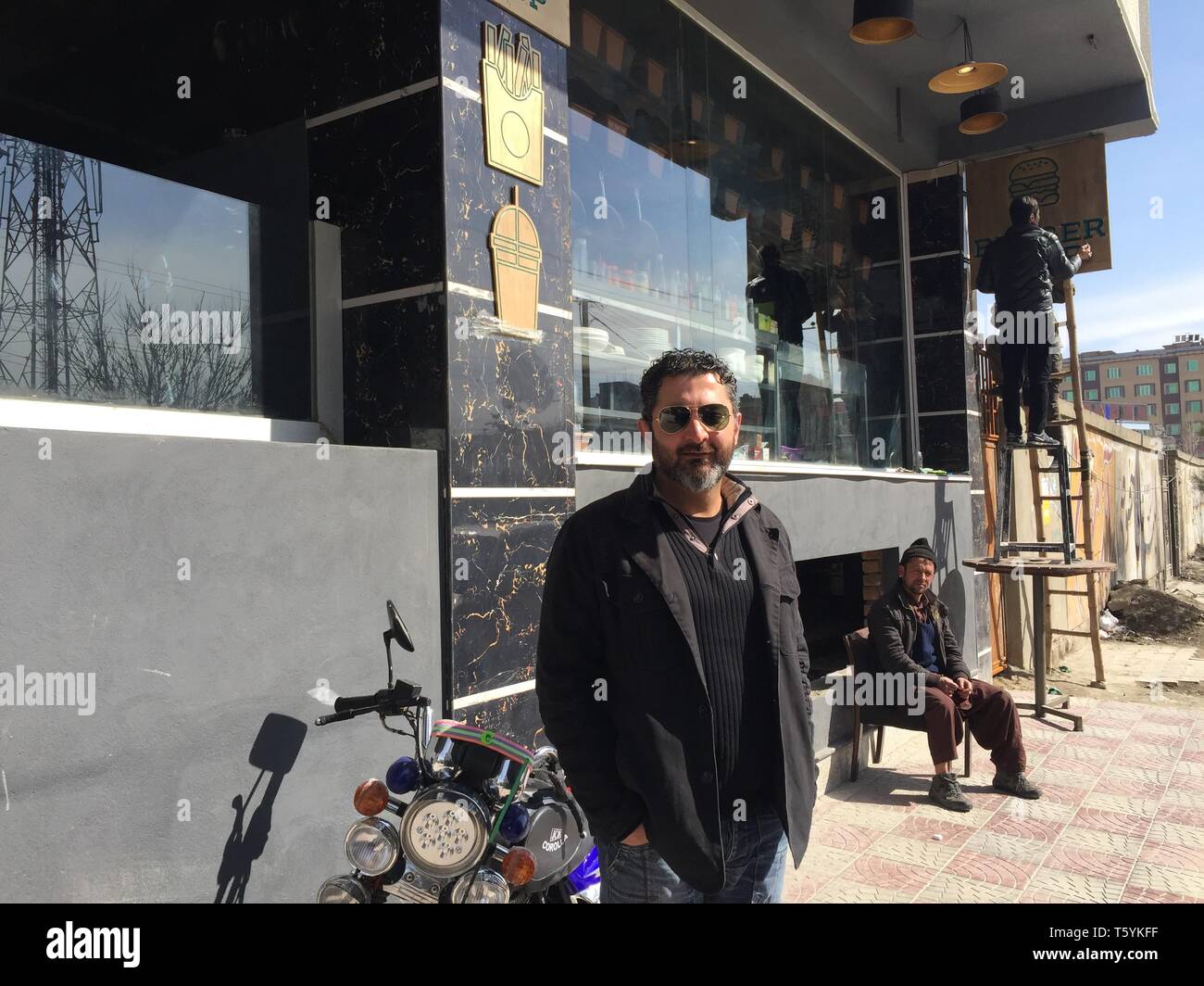 06 marzo 2019, Afghanistan Kabul: il locatore di Kabul Humajun Sadran sorge nella parte anteriore della sua nuova caffetteria-ristorante Burger Shop nel quartiere Taimani. Sadran è il grande maestro di intrattenimento a Kabul e ha rivoluzionato la vita notturna locale scena con prime feste da ballo per stranieri, più tardi arredate in modo creativo e caffetterie per gli afghani. La nuova caffetteria in scena a Kabul offre ai giovani piccola oasi di luce con Internet - e un rifugio per coloro la cui vita non si adatta più nei modelli tradizionali. (A dpa "Cool Kabul: il primo caffè e la gioventù afgana') Foto: Christine-Felice Röhrs/dpa Foto Stock