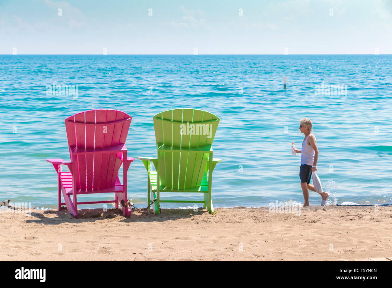 Due luminose terrazze colorate o sedie da spiaggia di Kew balmy spiaggia che si affaccia sul lago Ontario a Toronto Est, Canada Foto Stock