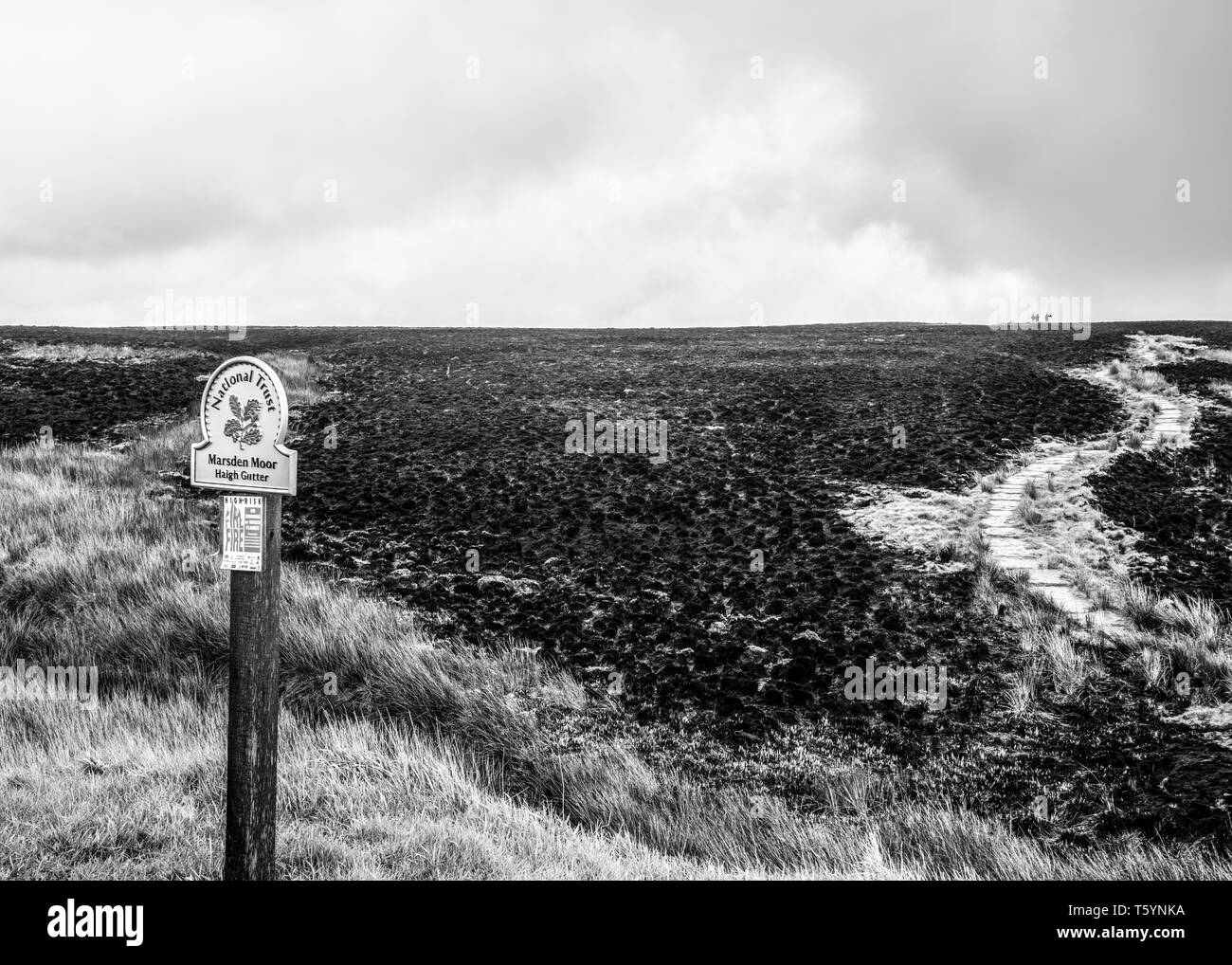 Un sentiero attraversa un paesaggio scena che era una volta wild heather ed è ora di cenere dopo gli incendi sparsi per il Moro. Foto Stock