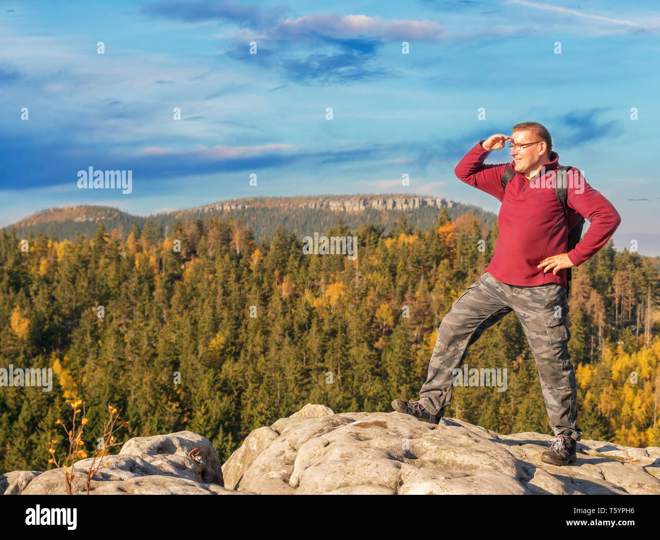 Escursionista con zaino in piedi sulla cima di una montagna ammirando la vista Foto Stock