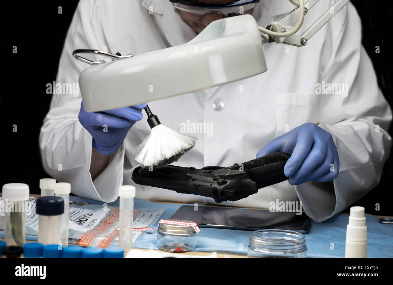 Polizia scientifica officer analizza la pistola per trovare tracce, immagine concettuale Foto Stock