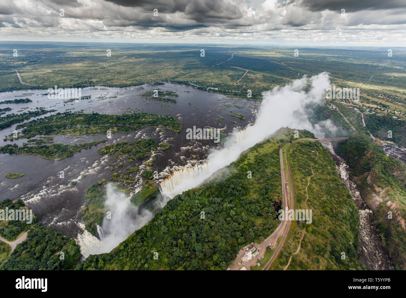 Longitudinale vista aerea dell'immenso la lunghezza del bordo di Victoria Falls in Africa con il sole che splende su di esso Foto Stock