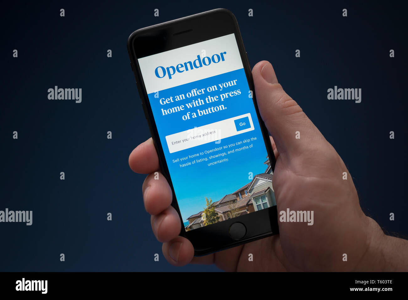Un uomo guarda al suo iPhone che visualizza il logo Opendoor (solo uso editoriale). Foto Stock