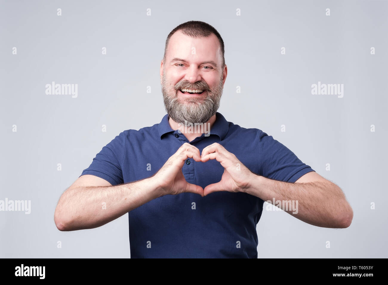 Coppia uomo europeo con la barba rendendo dalle mani di cuore. Foto Stock