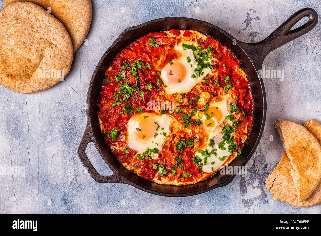 Shakshuka in una padella. Le uova in camicia in pomodoro piccante salsa di pepe. Foto Stock