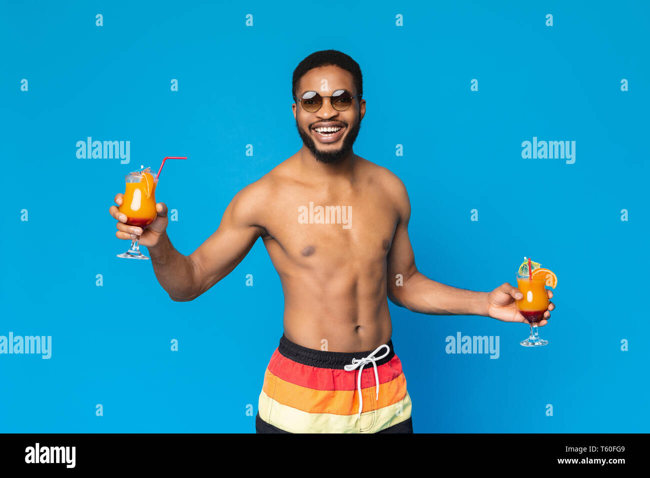 Allegro African American guy tenendo due cocktail estivo Foto Stock