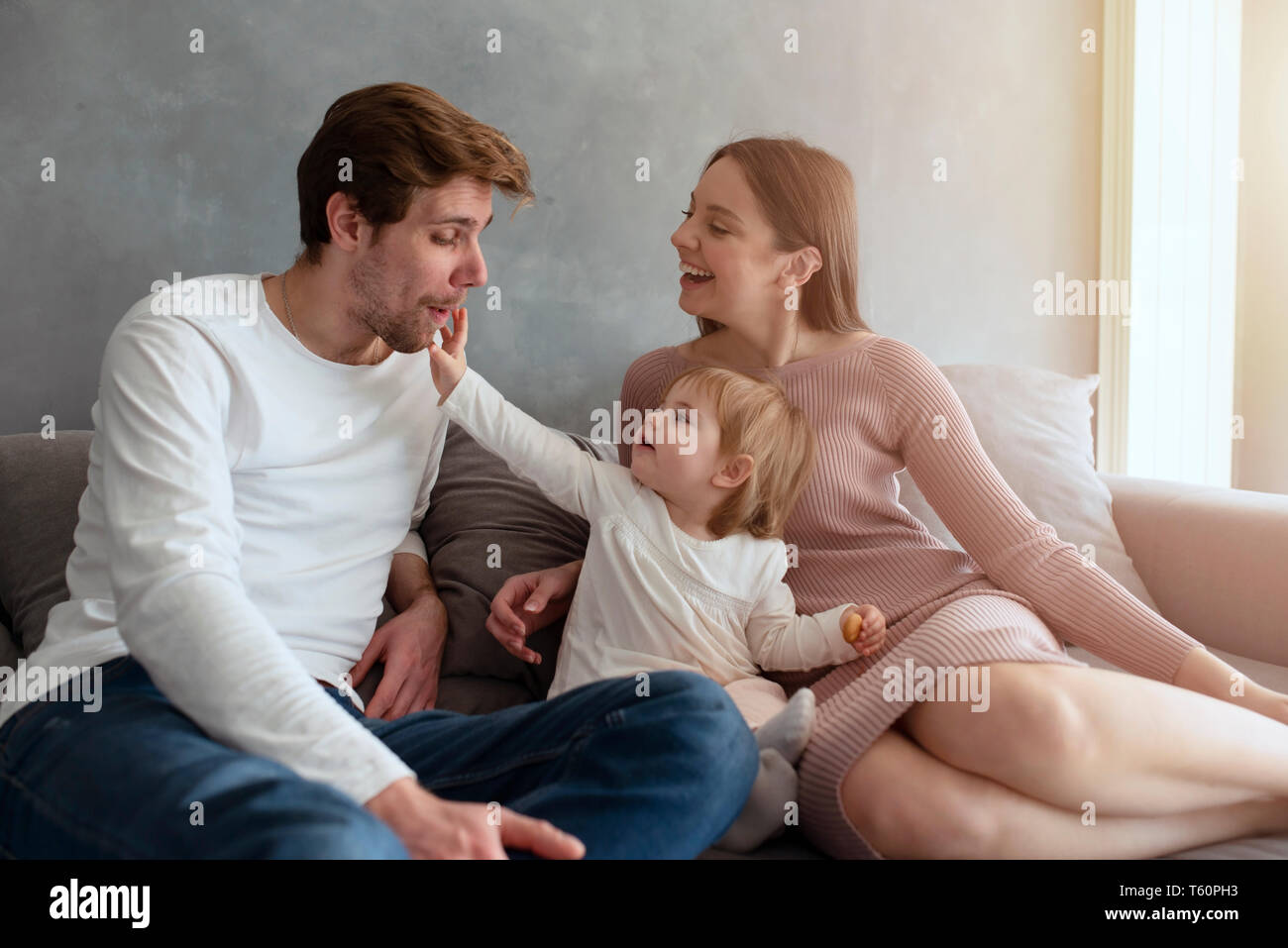 Felice bambina gioca con sua madre e suo padre Foto Stock