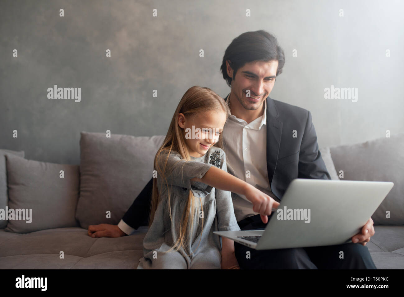 Felice bambina la visione di un filmato sul computer con il suo padre Foto Stock