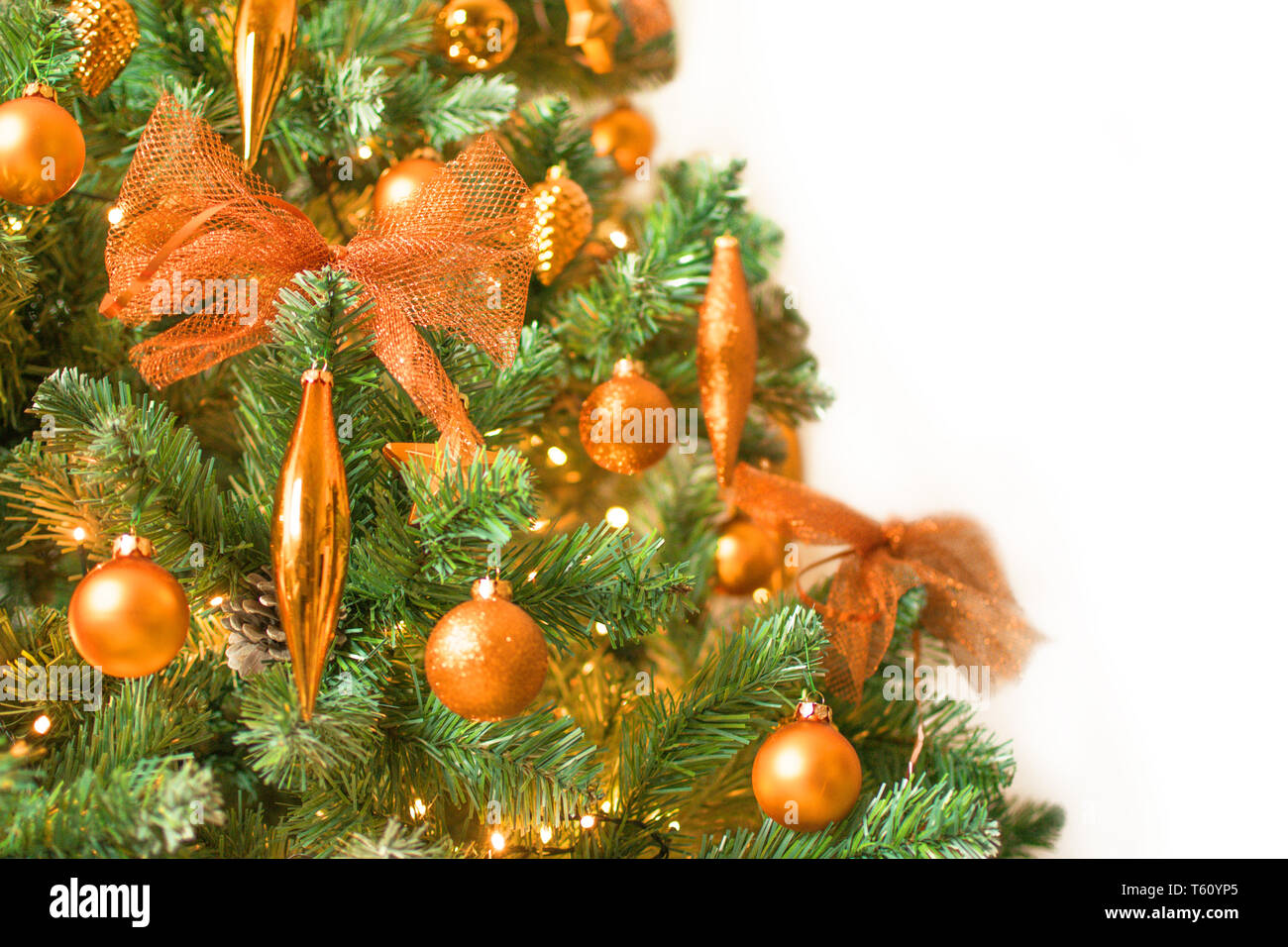 Dettaglio del moderno albero di Natale decorato con colore bronzo - ornamenti isolati su sfondo bianco sul lato sinistro Foto Stock
