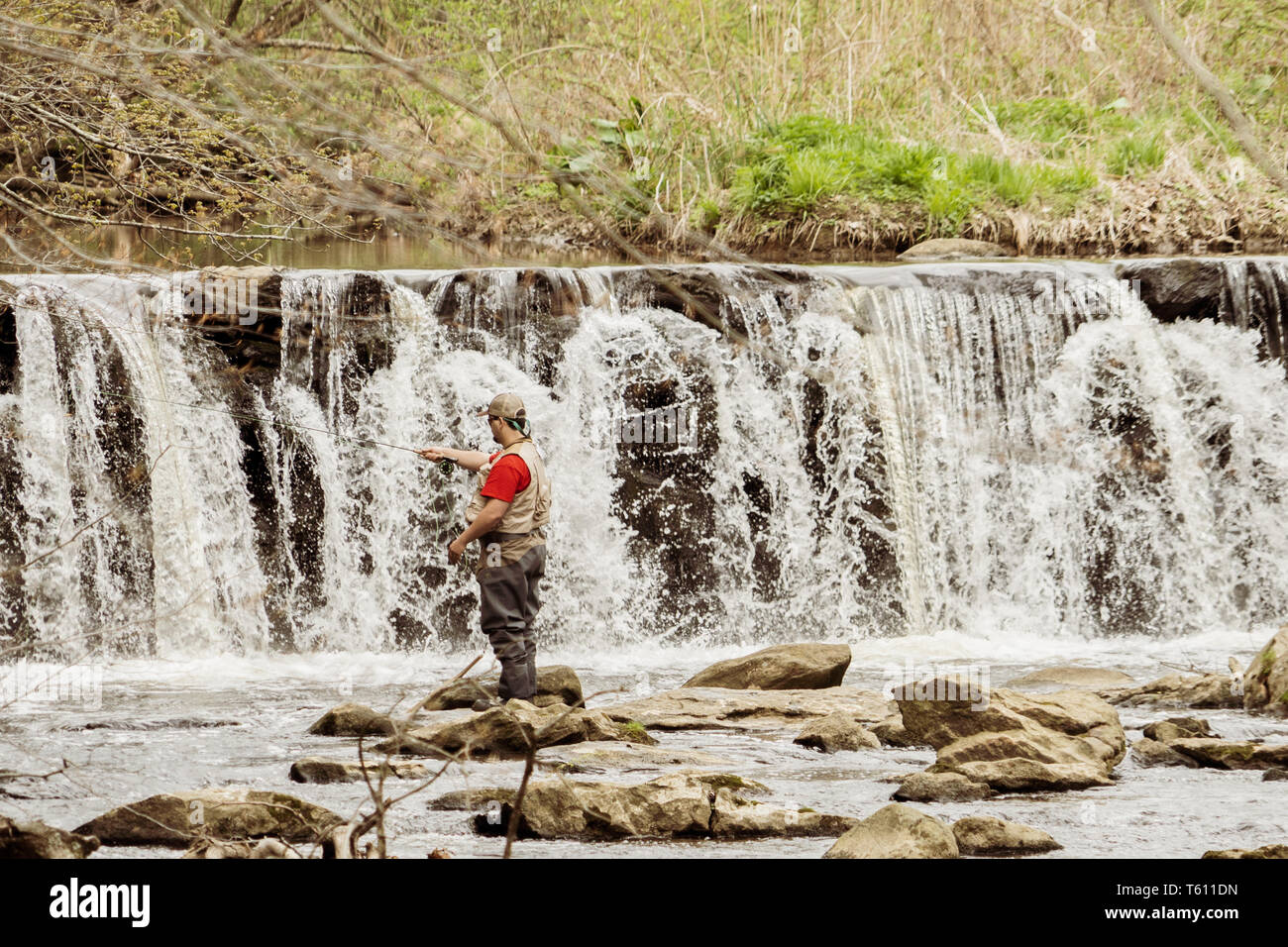 Uomo di pesca in Ridley Creek, in Ridly Creek parco dello stato nella parte orientale della Pennsylvania. A metà giornata nella primavera del tempo. Foto Stock