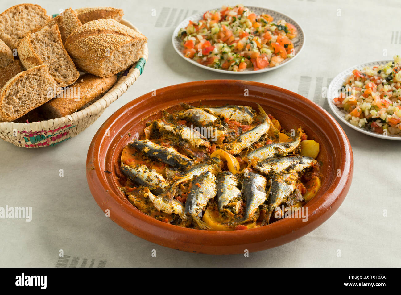 Marocchino tradizionale piatto con le sardine e le verdure, insalata e un cestello con pane Foto Stock