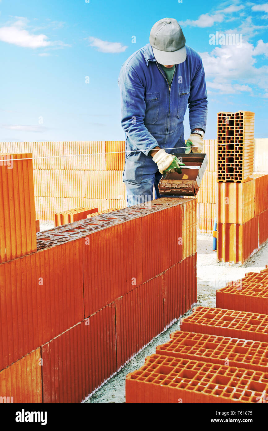 Mason la costruzione di un muro di mattoni. Foto Stock