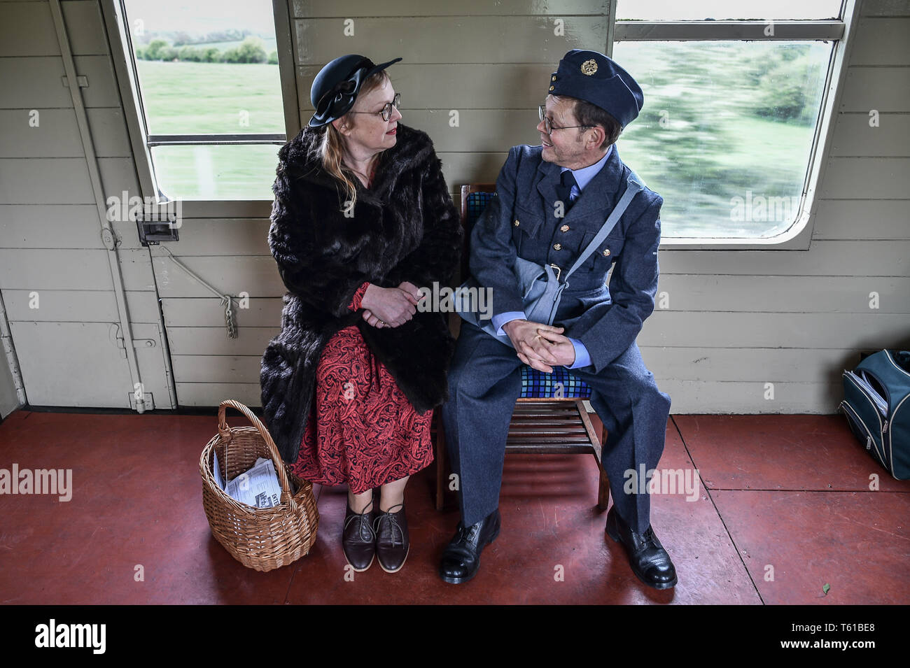 Persone vestite nel periodo della seconda guerra mondiale i vestiti chat su un treno a vapore durante il tempo di guerra in Cotswolds evento in Gloucestershire Warwickshire Steam Railway. Foto Stock