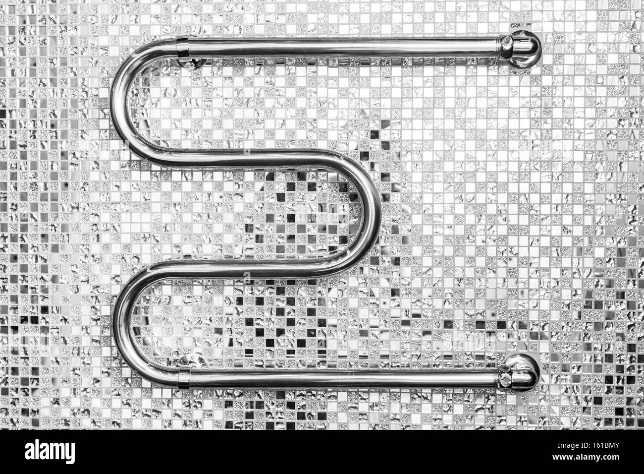 Bagno interno in stile art deco. Chrome scaldasalviette su uno sfondo dello specchio a mosaico di piastrelle di ceramica Foto Stock