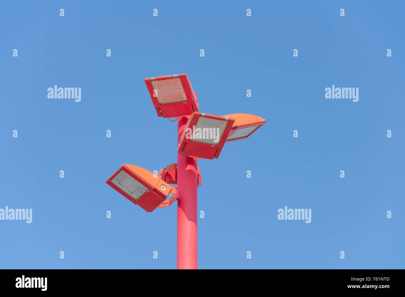 Close up di un led rosso palo di illuminazione con quattro lampade ed un cielo blu come sfondo in orizzontale Foto Stock