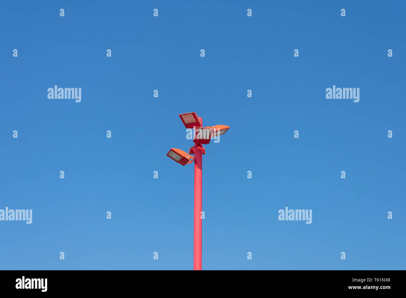 Led rosso palo di illuminazione con quattro lampade ed un cielo blu come sfondo Foto Stock