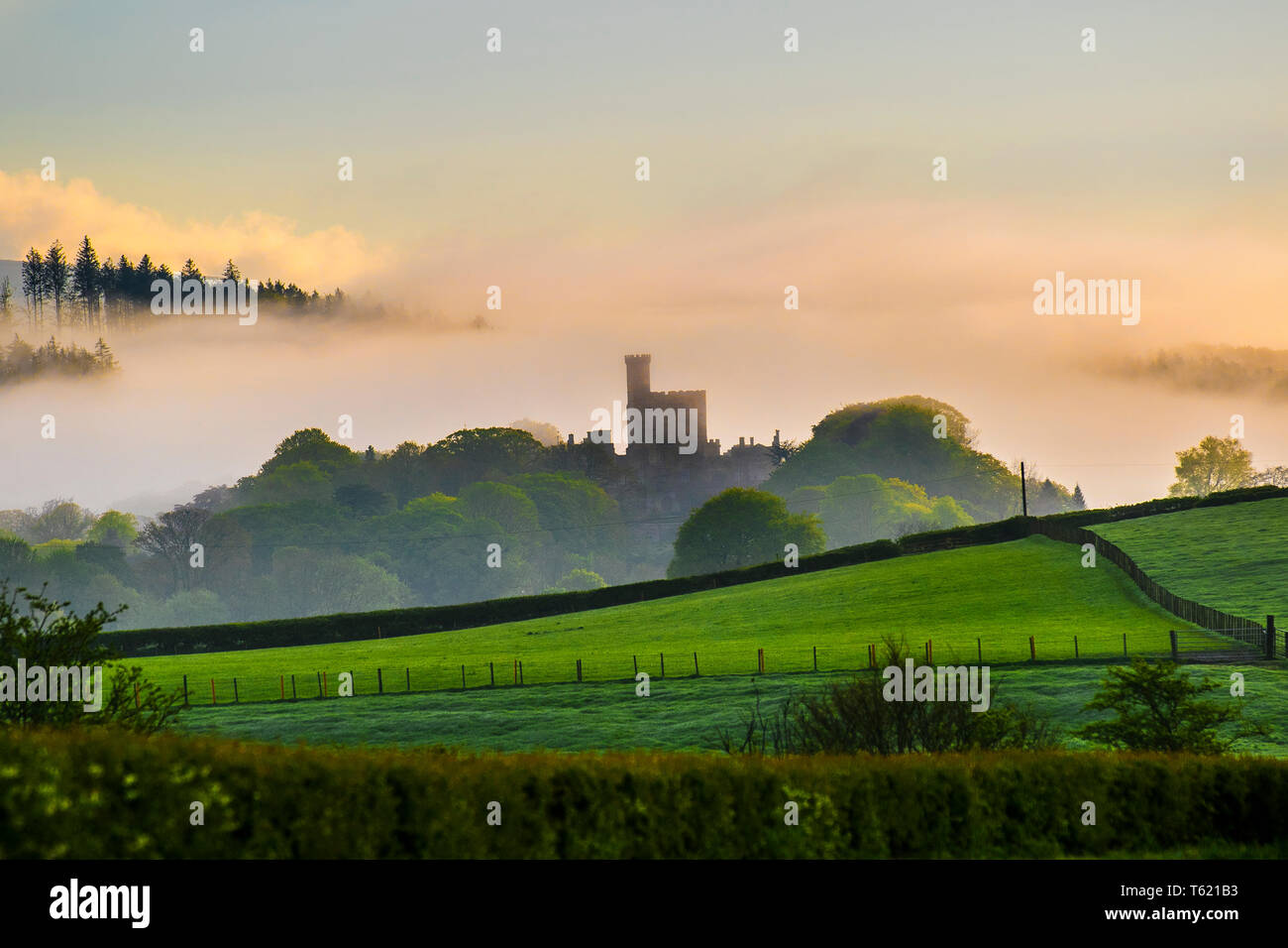 Hornby, Lancaster, Regno Unito Meteo. Misty, umido e frizzante aprile mattina sopra il Castello di Hornby e i campi calcinati del Lancashire rurale. Castello di Hornby una casa di campagna, sviluppata da un castello medievale, che si erge ad est del villaggio di Hornby nella Valle di Lune, Lancashire. Occupa una posizione che domina il villaggio in una curva del fiume Wenning. Foto Stock