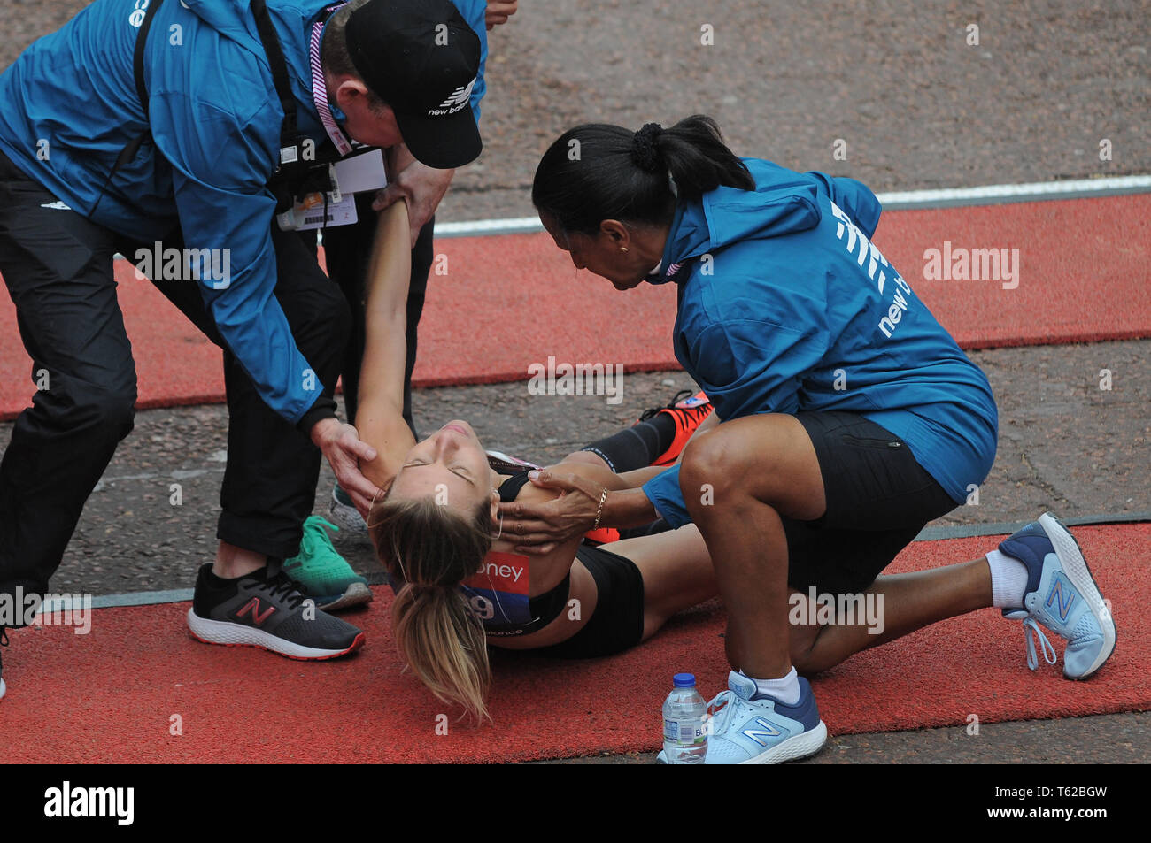 Londra, Regno Unito. 28 apr, 2019. Hayley Carruthers GB elite donne runner crolla al traguardo della Maratona di Londra. Crollò a terra prima di raggiungere il traguardo, strisciato la linea e poi è stata assistita dal primo aiuto. Credito: JOHNNY ARMSTEAD/Alamy Live News Foto Stock