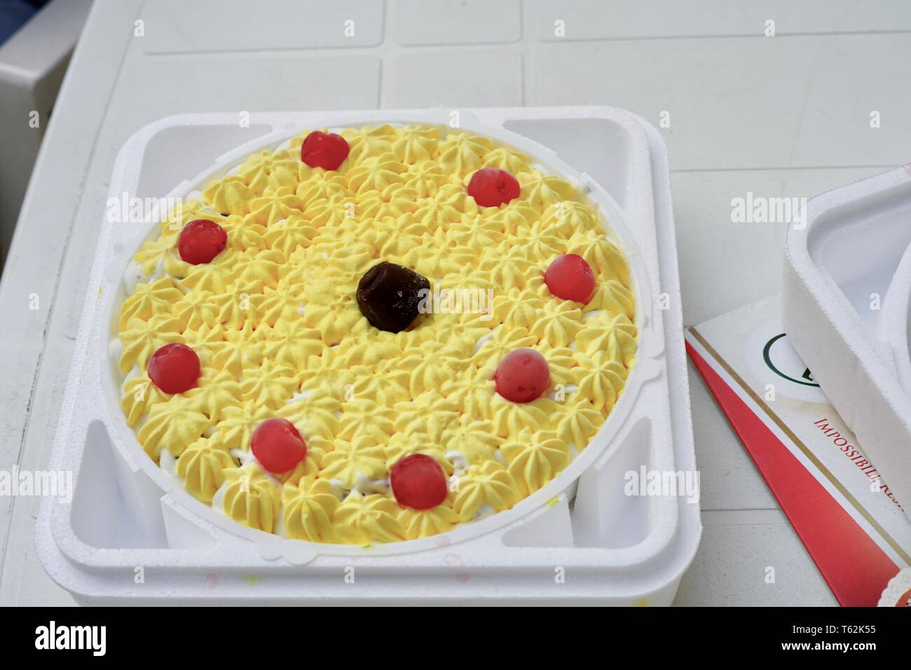 Un bel giallo ciliegia torta di compleanno Foto Stock