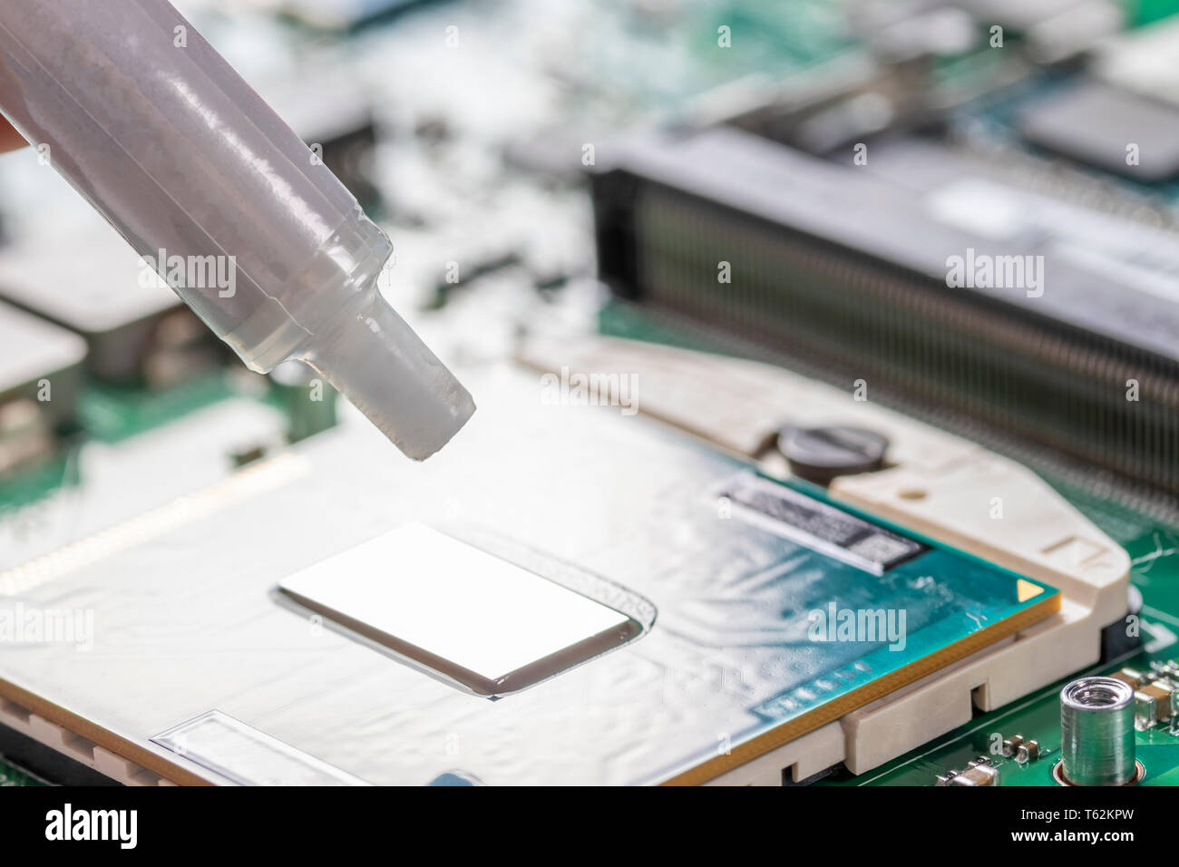 Un tubo di grasso termico sopra il chip del processore. Parte del laptop Foto Stock