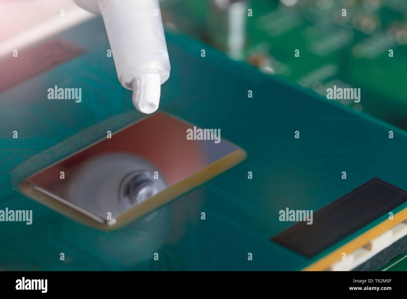 Un tubo di grasso termico sopra il chip del processore. Montaggio del computer stadio. Parte del laptop Foto Stock