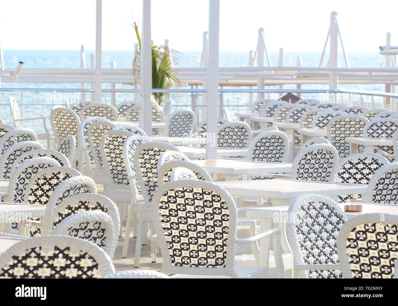 Bianco mobili di plastica in un cafè sulla costa prima dell' inizio della stagione di spiaggia Foto Stock