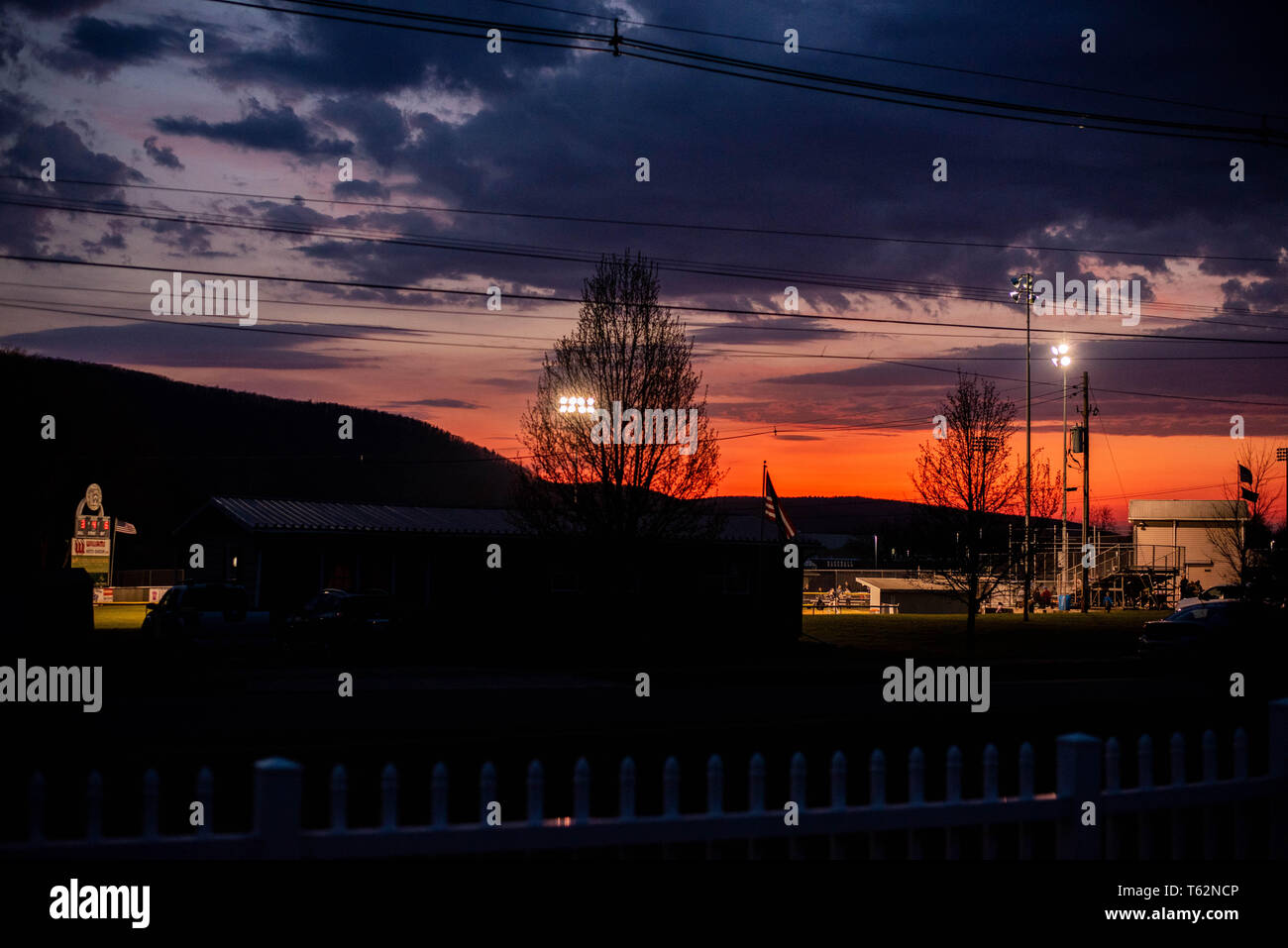 Il sole tramonta in una piccola città americana, che si affaccia su un piccolo campo di campionato. Foto Stock
