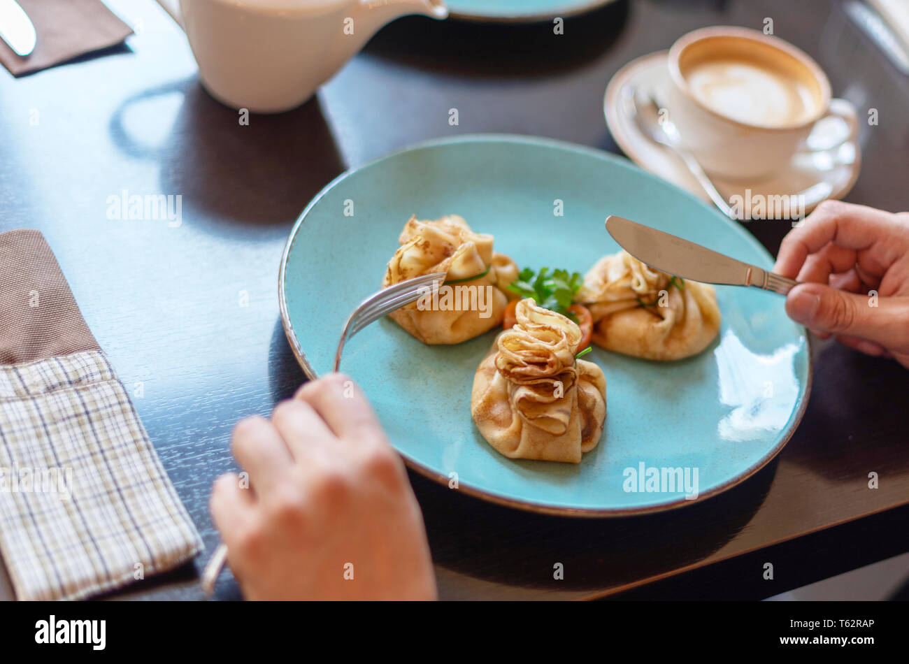 L'uomo mangiare pancake per colazione Foto Stock