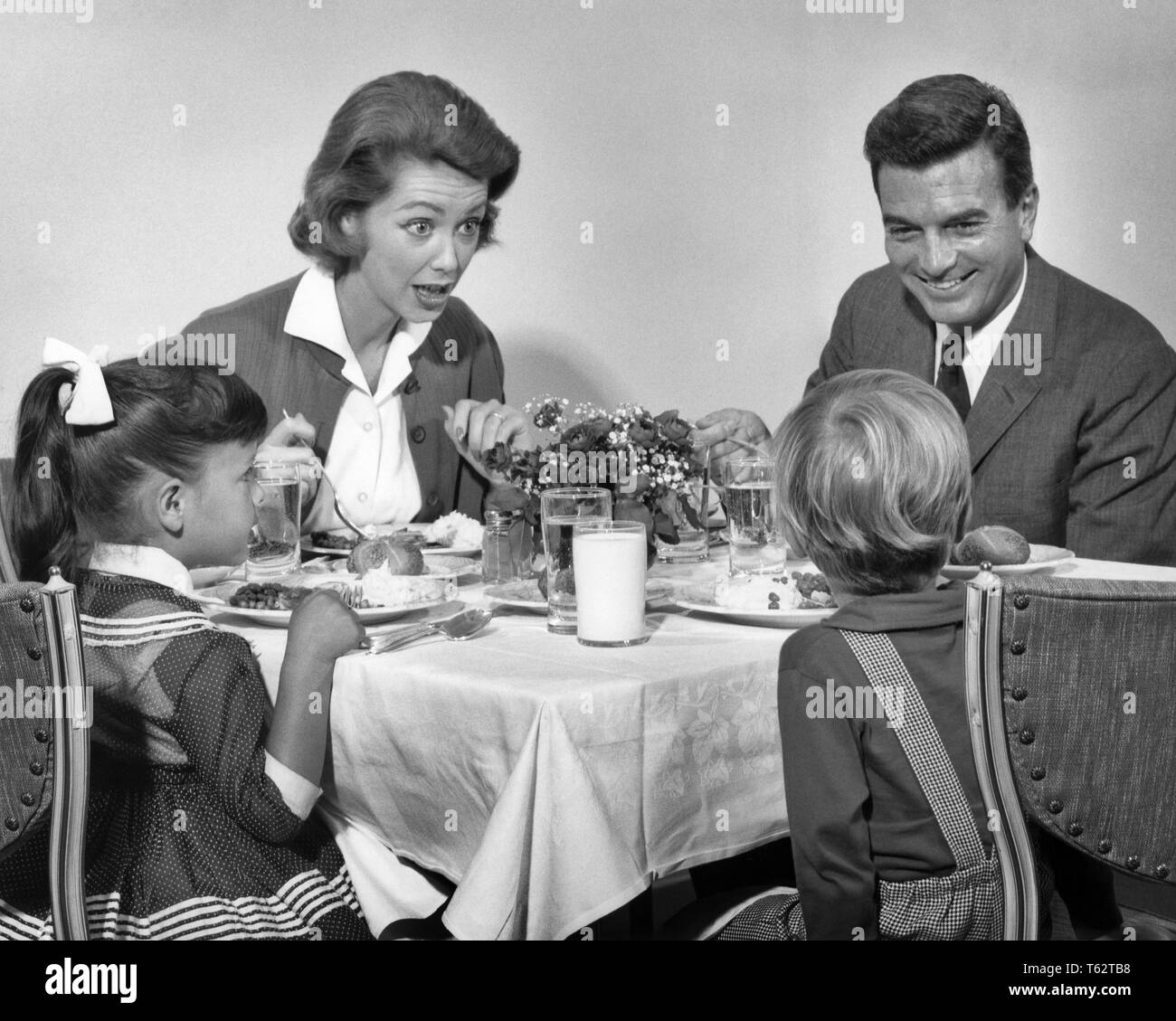 Negli anni sessanta la famiglia di quattro di mangiare la cena insieme - d1469 HAR001 HARS quattro pasto serale all'interno di MOM facce ascolto nostalgico coppia 4 suburbane madri urbano espressione vecchio tempo sorpresa NOSTALGIA FRATELLO OLD FASHION SORELLA 1 capretti facciale equilibrio COMUNICAZIONE TEAMWORK FIGLI LIETA GIOIA LIFESTYLE celebrazione di Parenting femmine sposato fratelli coniuge mariti salubrità HOME VITA comunicante a mezza lunghezza LADIES figlie persone cura maschi spiritualità fratelli sorelle espressioni padri B&W indossare giacca e cravatta felicità allegro forza papà di opportunità di pari livello concettuale sorride gioiosa novellame Foto Stock