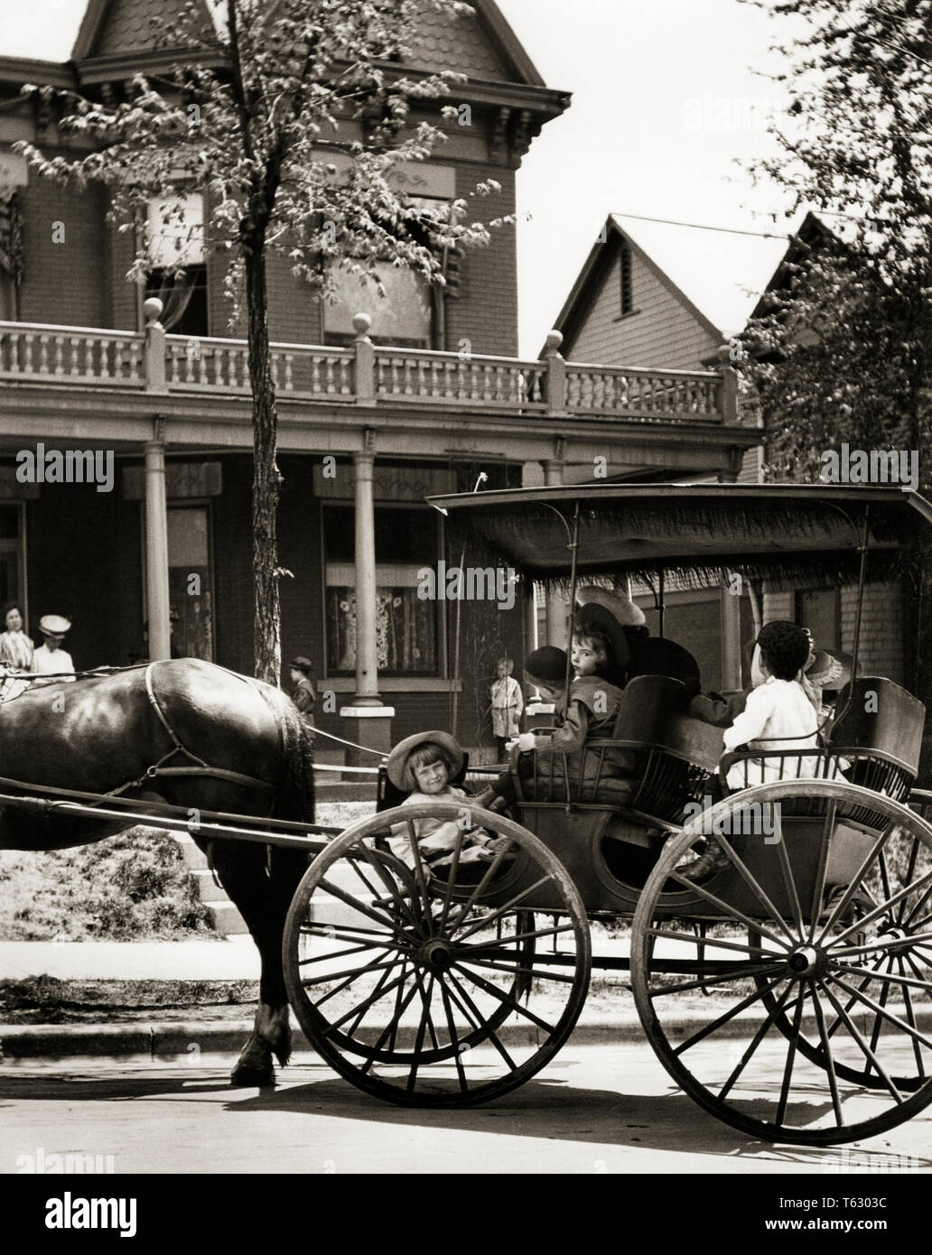 1890s 1900 GRUPPO DI RAGAZZI E RAGAZZE seduti nel Surrey con frangia sul carrello superiore nella parte anteriore del giro del ventesimo secolo la casa - Q74728 CPC001 HARS CELEBRAZIONE BUGGY HOME VITA trasporto di lusso a mezza lunghezza persone trasporto residenziale B&W carrello felicità mammiferi testa e spalle FRINGE Giro del 20esimo secolo emozioni a cavallo il mobility equino elegante cavallo creatura mammifero relax convivere animali cavalli in bianco e nero in vecchio stile Foto Stock