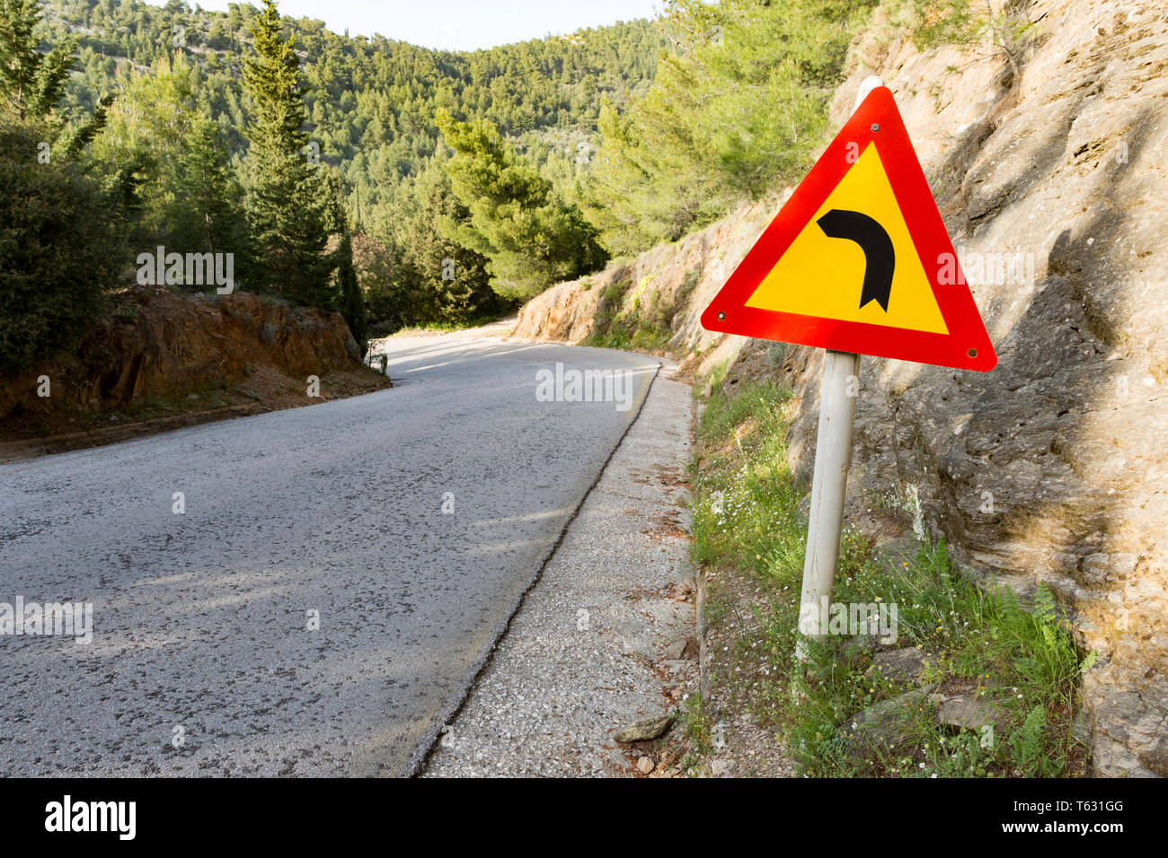 Segnale di avvertimento per il pericoloso girare a sinistra in montagna Foto Stock