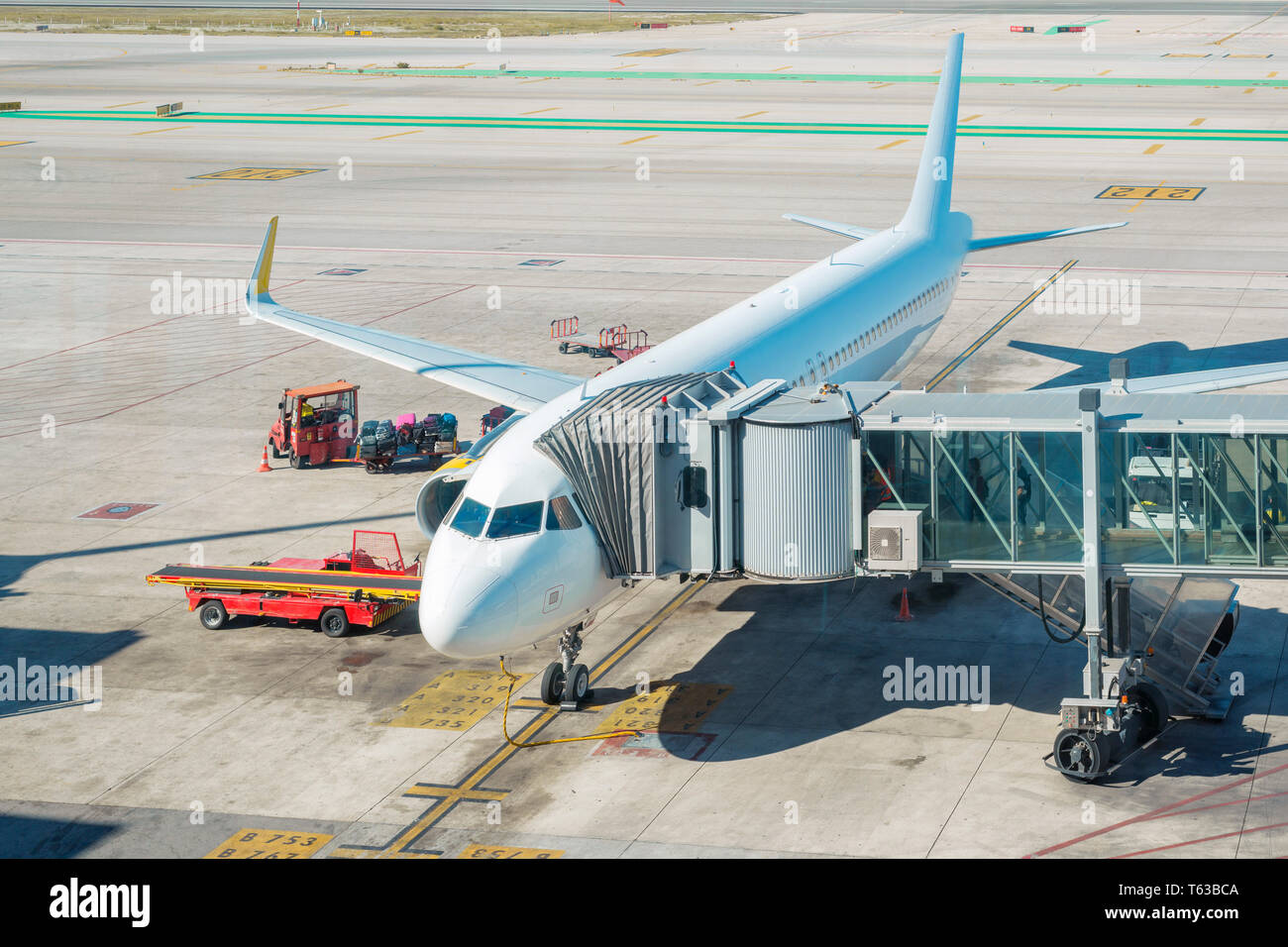 Aeroplano bianco al cancello di imbarco dalla luminosa giornata di sole Foto Stock
