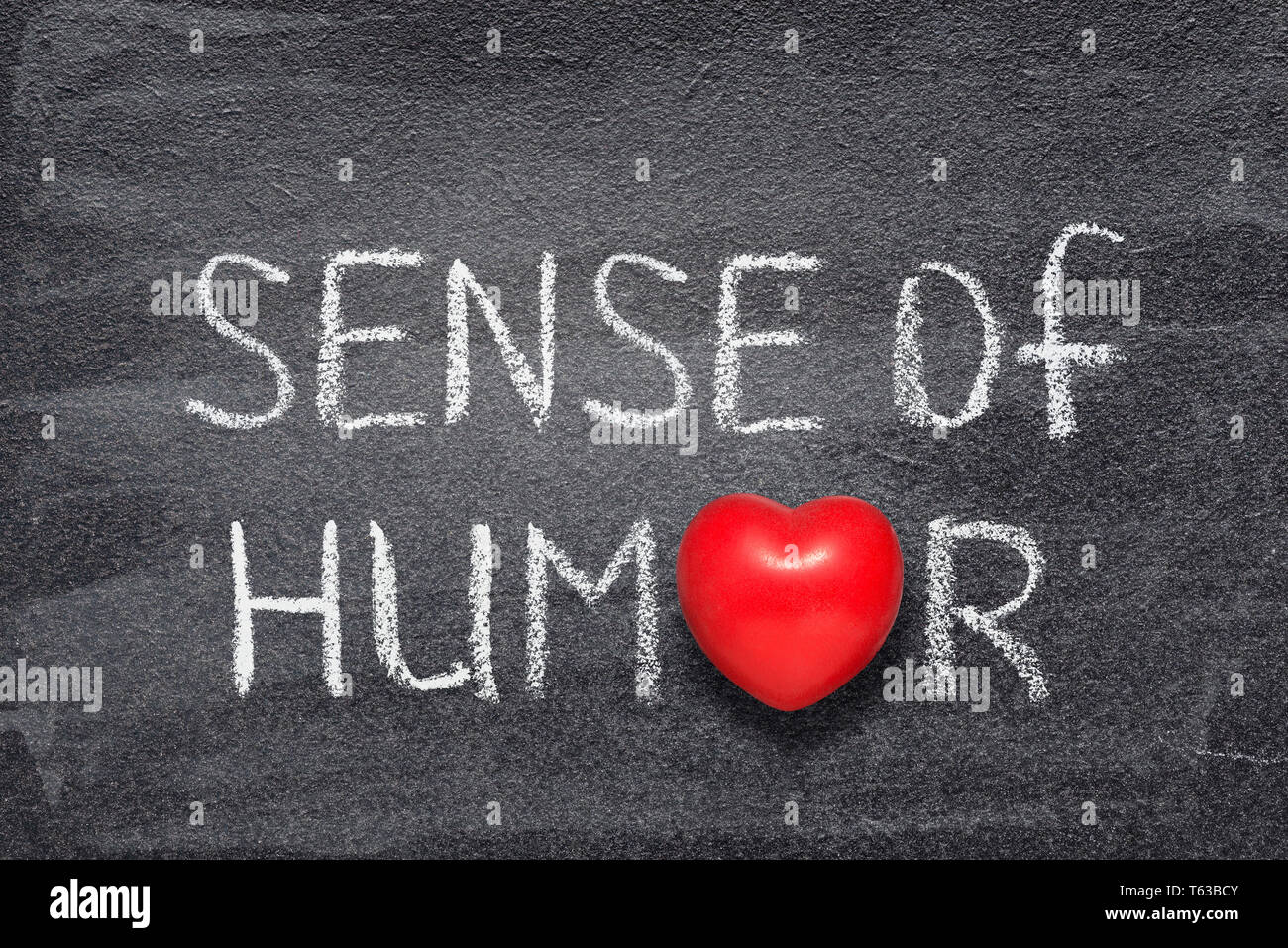 Senso dell'umorismo una frase scritta a mano sulla lavagna con cuore rosso simbolo invece di o Foto Stock