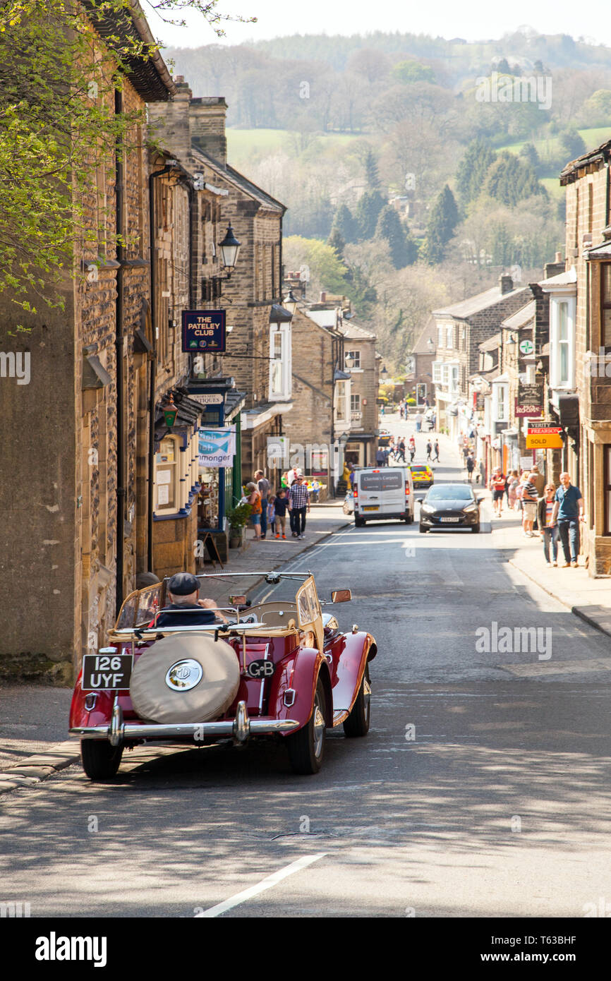 Uomo alla guida di un classico 1950 MG TD open top auto sportiva attraverso le Yorkshire Dales cittadina di ponte Pateley Yorkshire Inghilterra Foto Stock