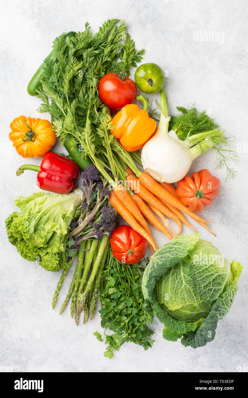 Fresche verdure crude su off lo sfondo bianco, vista dall'alto, il fuoco selettivo Foto Stock