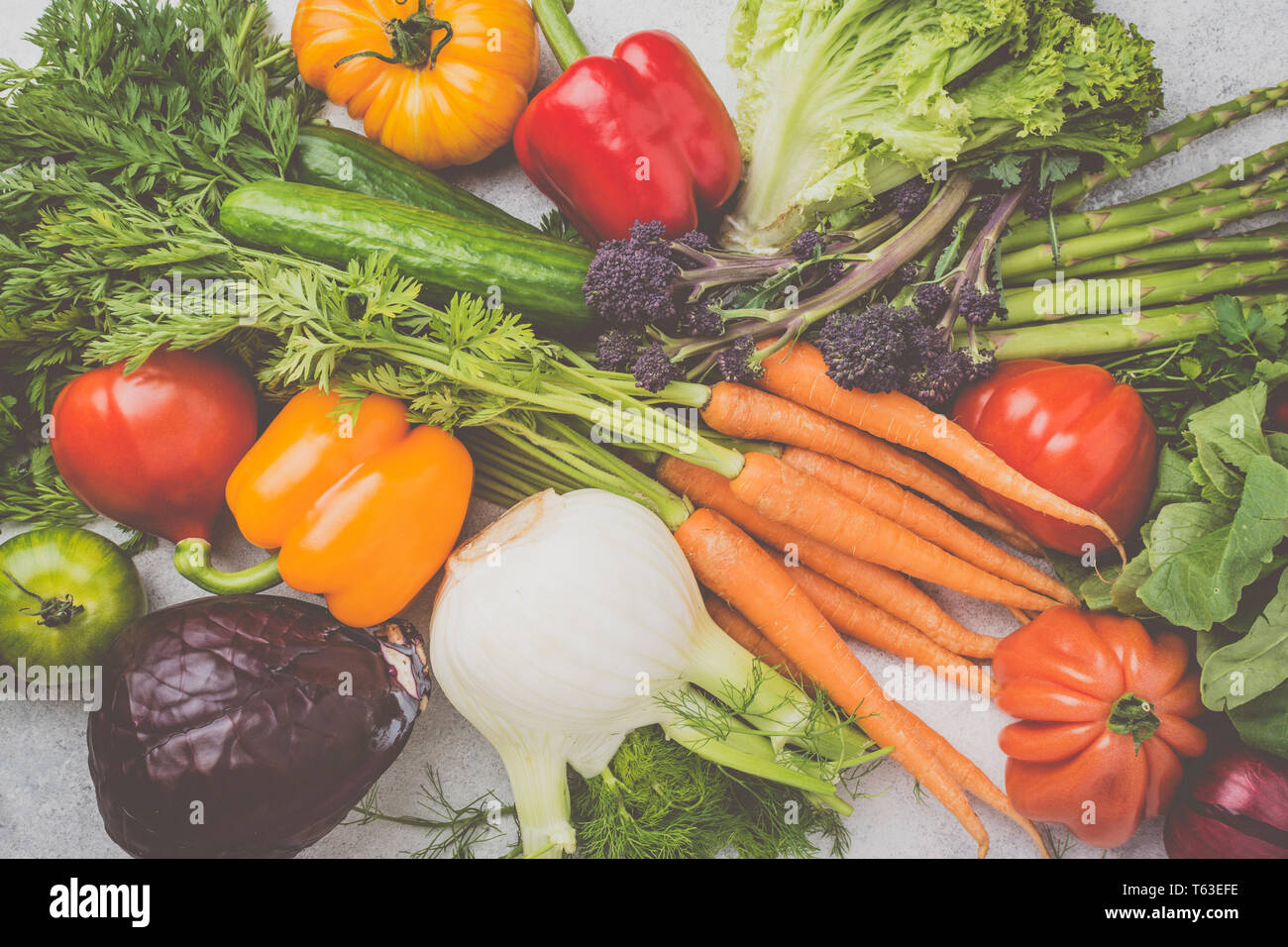 Fresche verdure crude sfondo, carote Cavolo broccoli asparagi pepe finocchio insalata di pomodori on off tavolo bianco, vista dall'alto, tonica, il fuoco selettivo Foto Stock