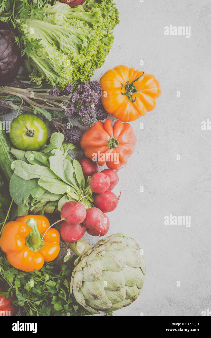 Fresche verdure crude su off lo sfondo bianco, vista dall'alto, tonica, il fuoco selettivo Foto Stock