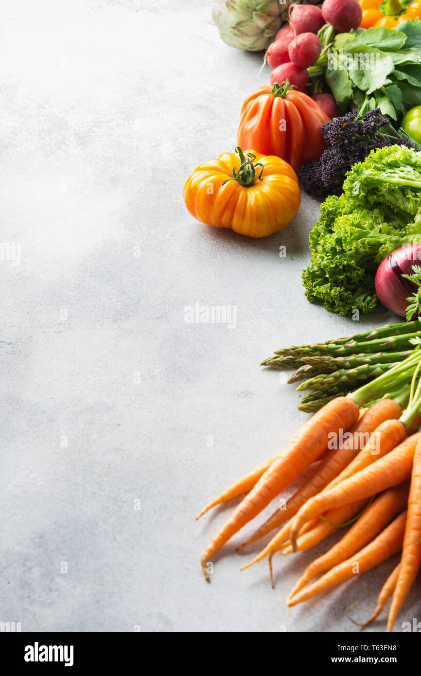 Fresche verdure crude su off lo sfondo bianco, copia di spazio, il fuoco selettivo Foto Stock