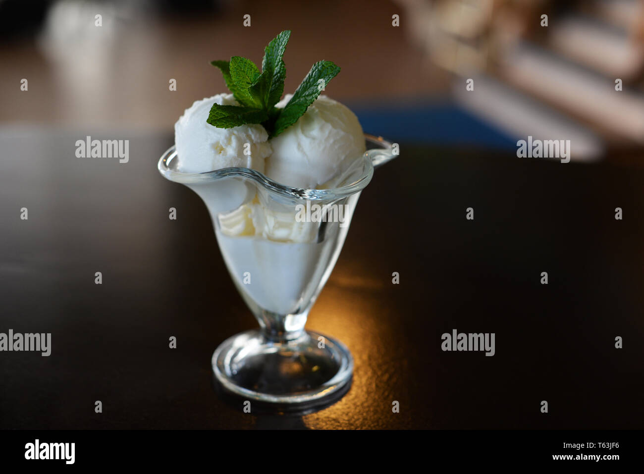 Palle di gelati in un bel bicchiere con un rametto di menta in un ristorante Foto Stock