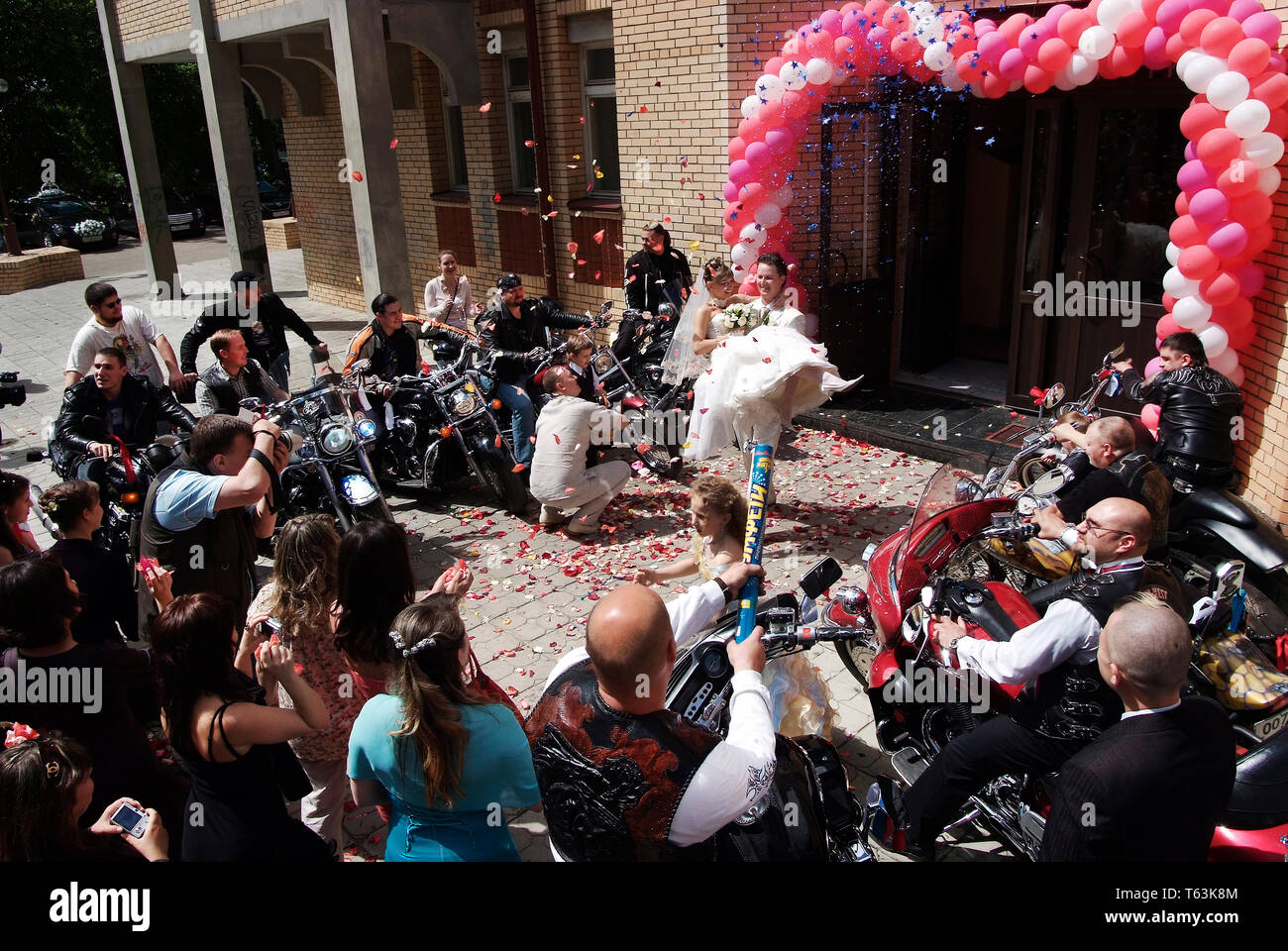 06/08/2008Mosca, Russia. Lo sposo porta la sposa nelle sue braccia .Bikers seduta bike e soddisfare un paio di lasciare il cancelliere Foto Stock