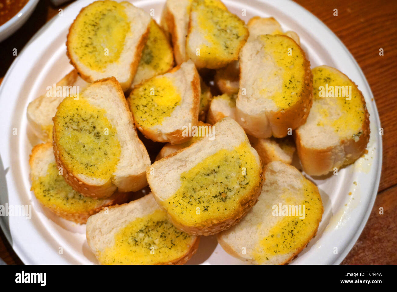 Deliziosa aglio le fette di pane con burro formaggio prezzemolo cipollina sana colazione sulla piastra bianca tostata baguette croccanti piatto di lato Foto Stock