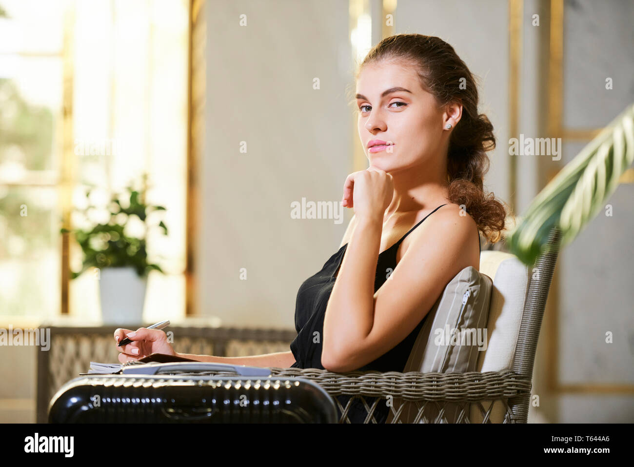 Attraente giovane donna nella hall hotel Foto Stock