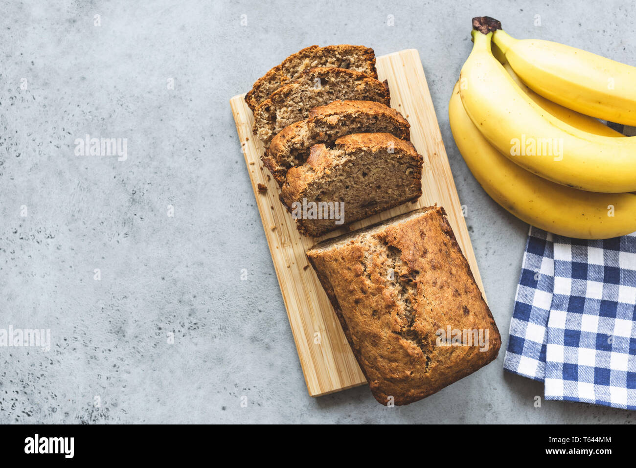 Pane alla banana focaccia con mandorle a fette dadi sul cemento grigio Sfondo. Tabella vista superiore e spazio di copia Foto Stock