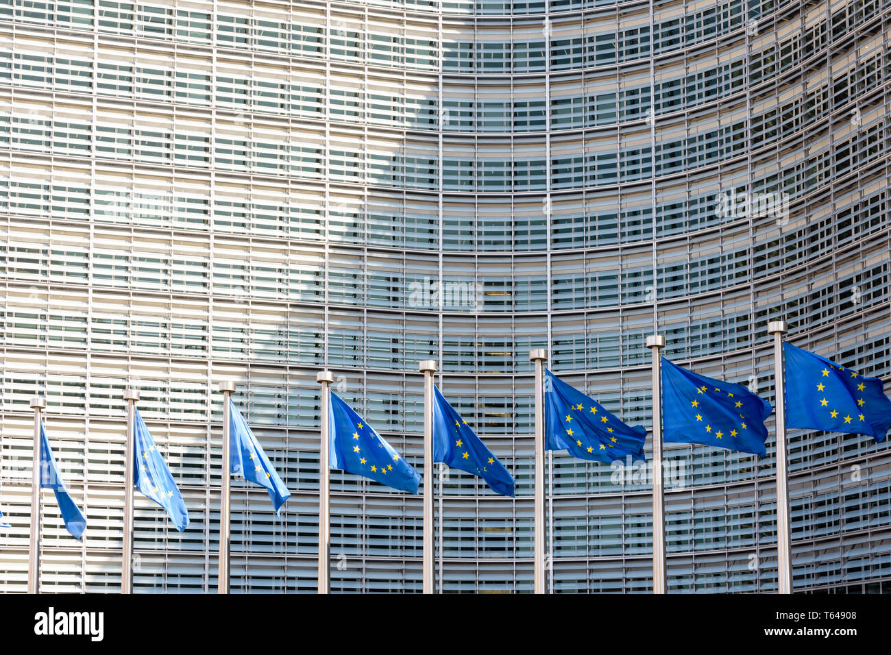 Una fila di bandiere europee al vento di fronte all'edificio Berlaymont, sede della Commissione europea a Bruxelles, in Belgio. Foto Stock