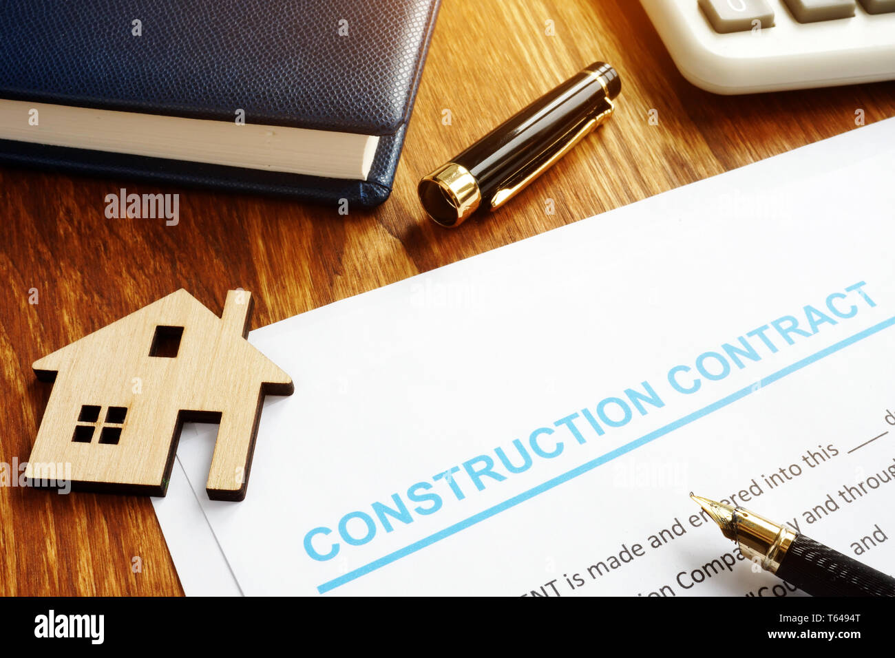 Contratto di costruzione, modello di casa e calcolatrice. Foto Stock