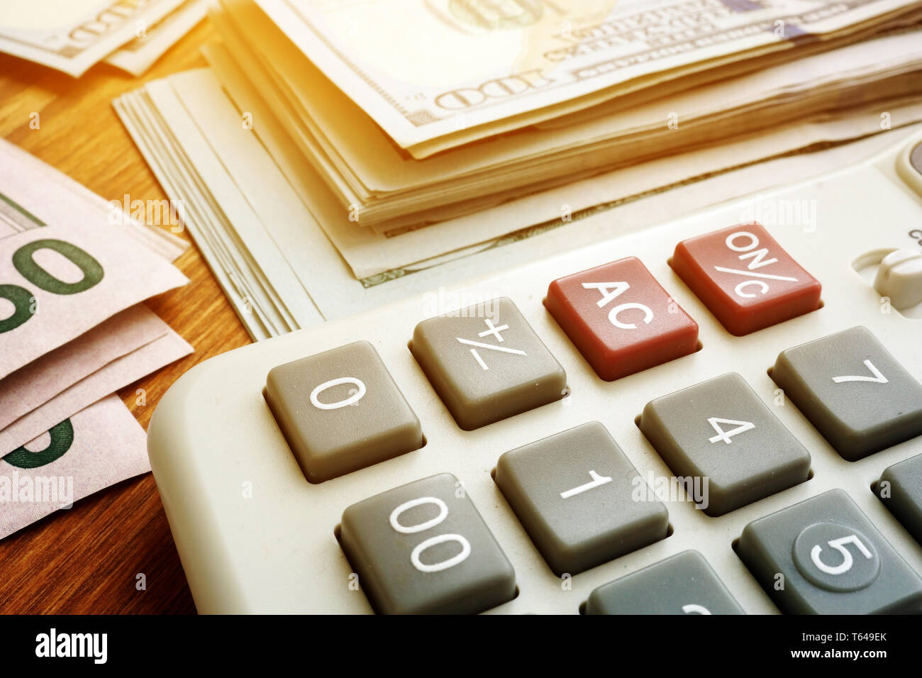 Pila di denaro e calcolatrice. Il budget e il concetto di risparmio. Dollaro banconote sulla scrivania. Foto Stock