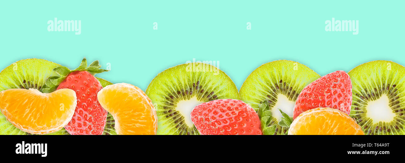 Fette di Kiwi, tangerini fragole blu su sfondo panoramico. Frutti di banner per il web. Foto Stock