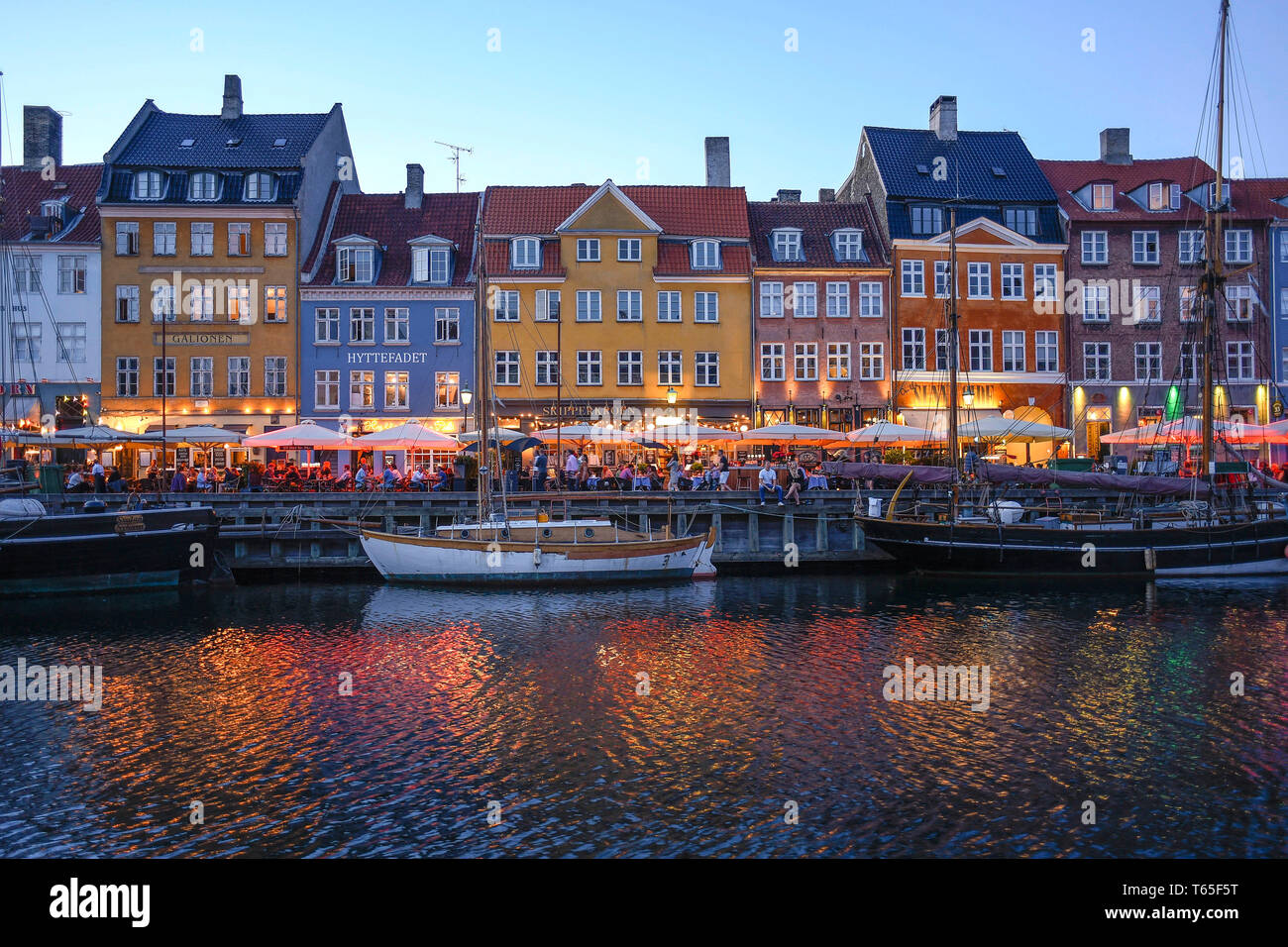 Storico del XVII e XVIII secolo edifici lungo il canale di Nyhavn, il quartiere del divertimento rivestite con coloratissime case a schiera, bar e caffè, Copenaghen, De Foto Stock