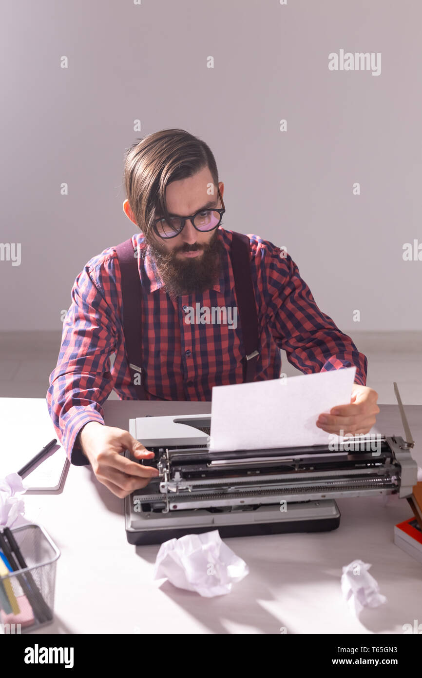 Scrittore del giorno e il concetto di tecnologia - scrittore bello circondato da sfridi di carta incentrata sul lavoro su sfondo grigio Foto Stock